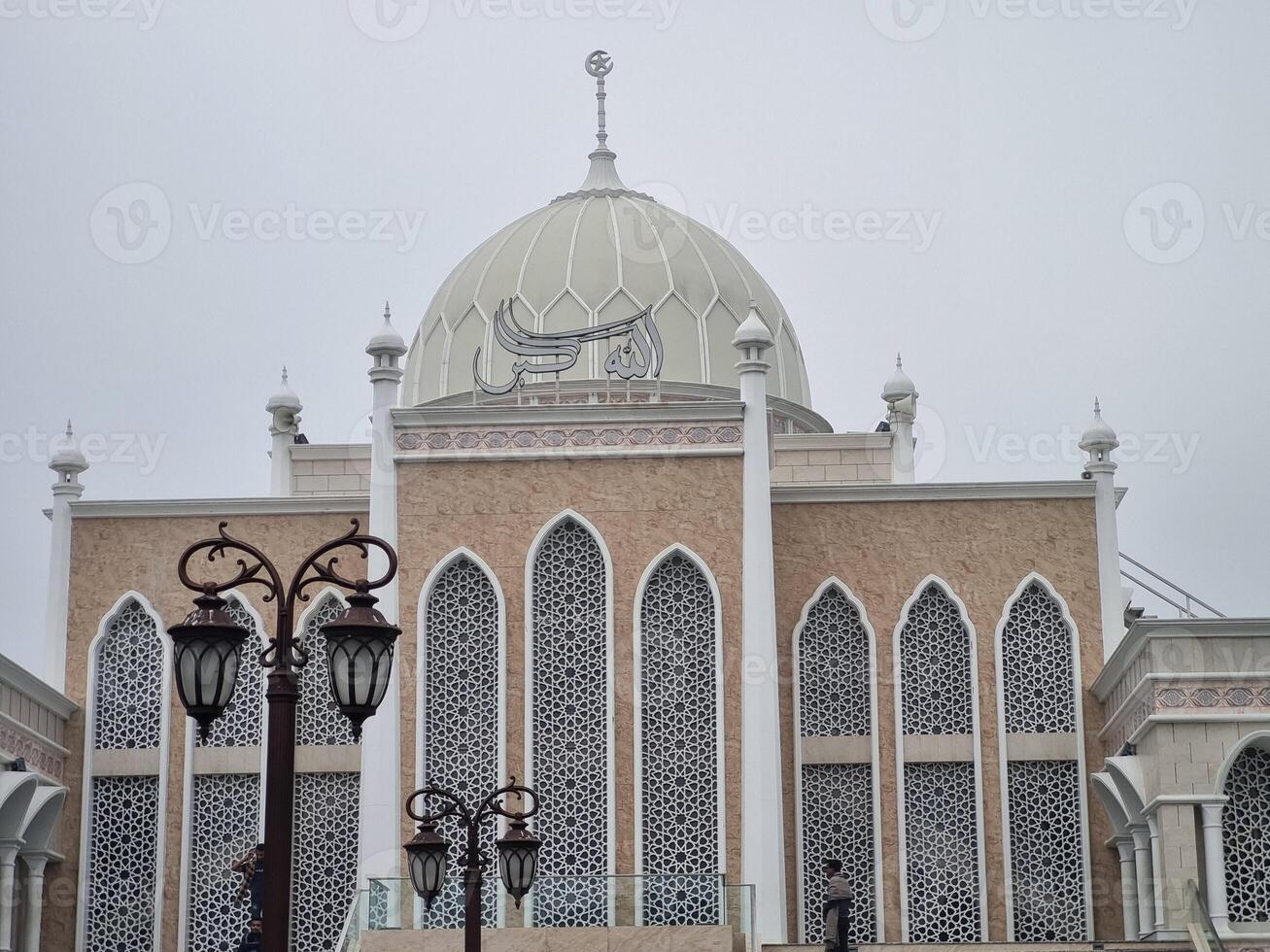 A majestic mosque with a prominent dome under a cloudy sky photo