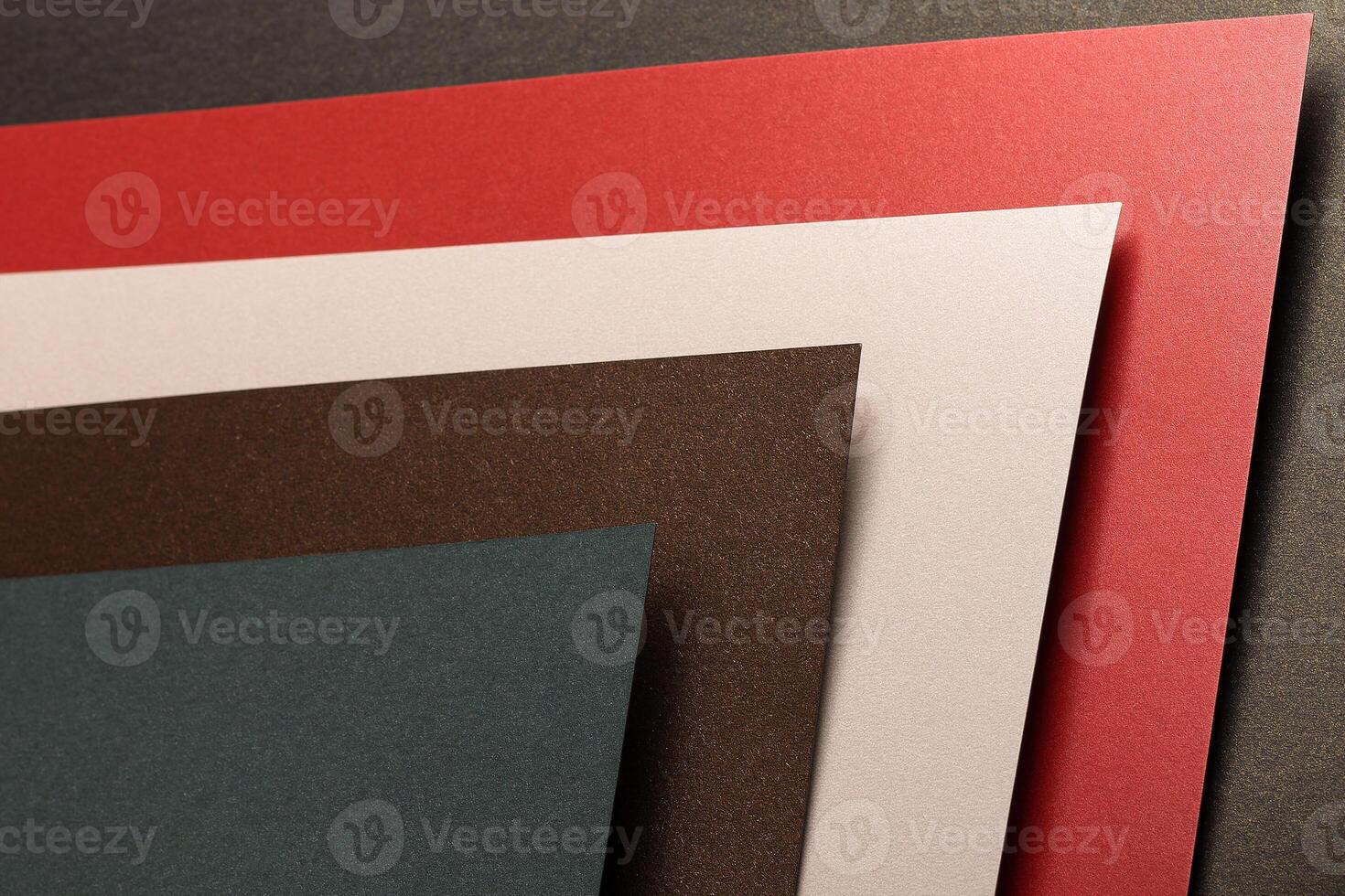 Paper background with matte texture. Fan spread composition with layered sheets in crimson red, pine photo