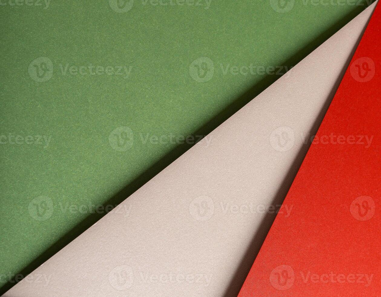 Paper background with matte texture. Layered diagonal sheets in crimson red, pastel green, mint photo