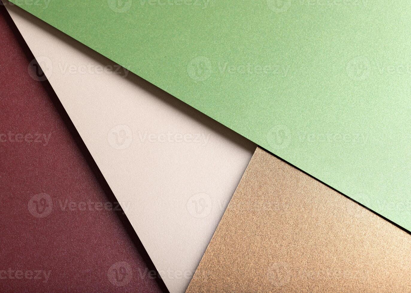 Paper background with matte texture. Layered diagonal sheets in burgundy, maroon, pastel green, photo