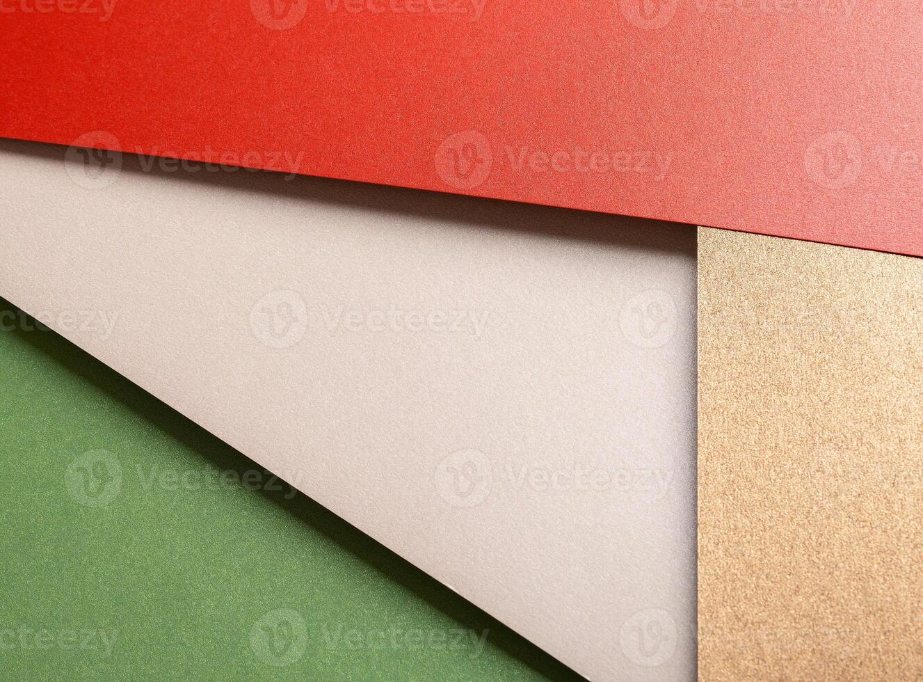 Paper background with matte texture. Layered diagonal sheets in bright red, pastel green, champagne, photo
