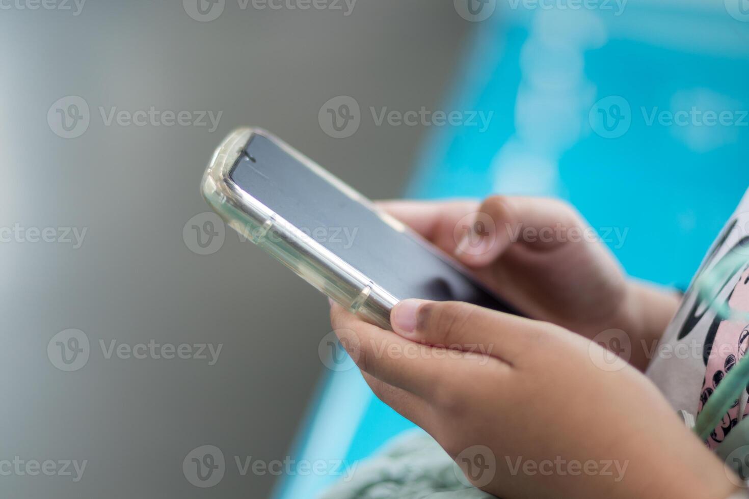 Close up view of a little girl's hand using a smartphone in public transportation photo