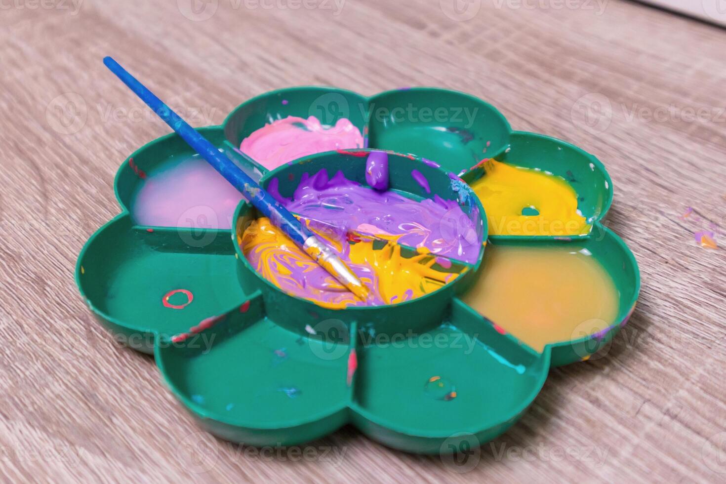 A paintbrush on a watercolor palette on the table photo