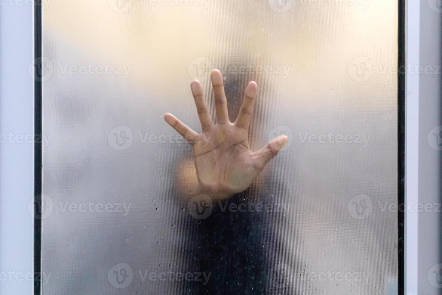 Hand behind frosted glass door. photo