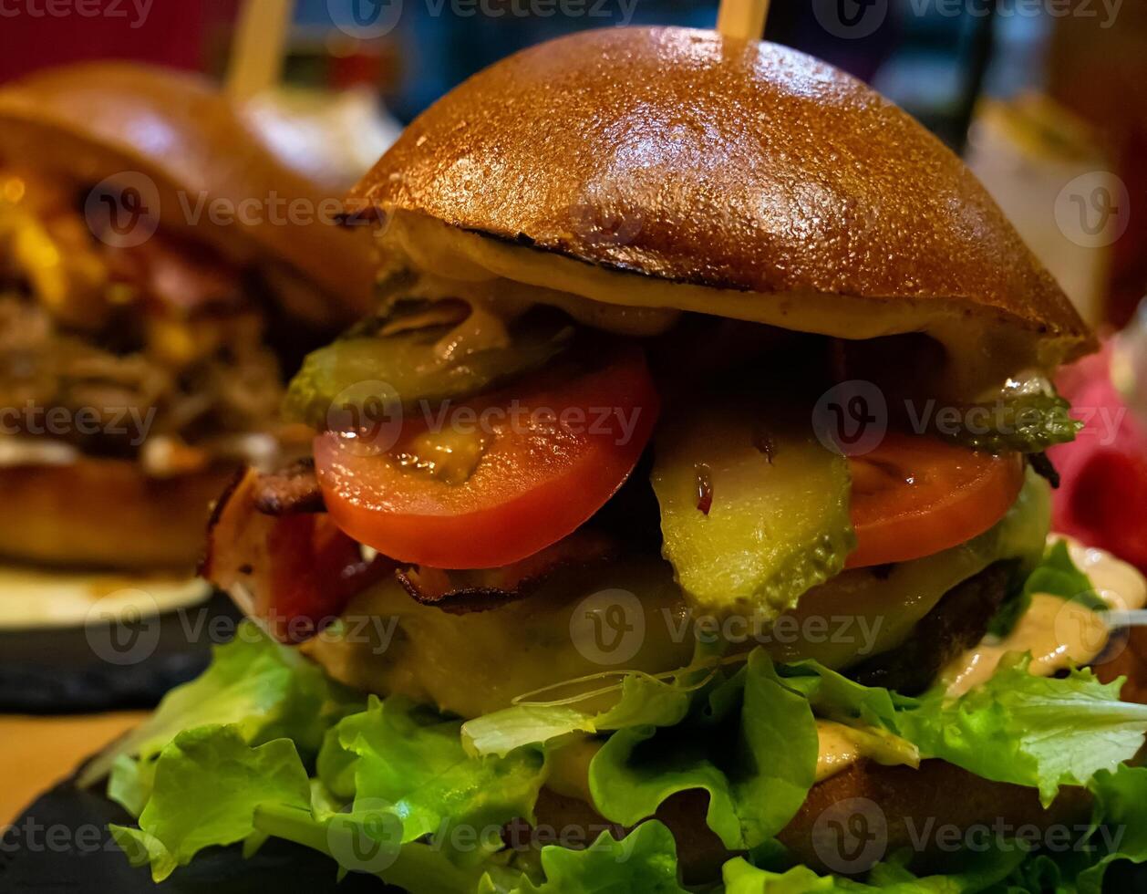 Close-up of a Bacon Swiss Burger with Pickles photo