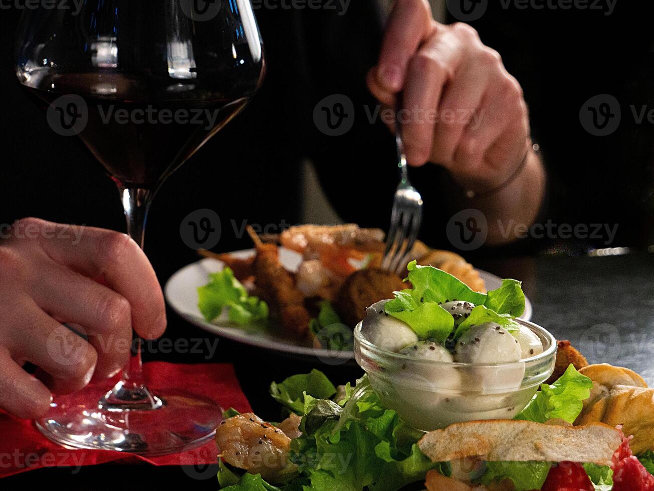 A Culinary Moment Red Wine Accompanies a Delectable Plate of Mixed Appetizers photo