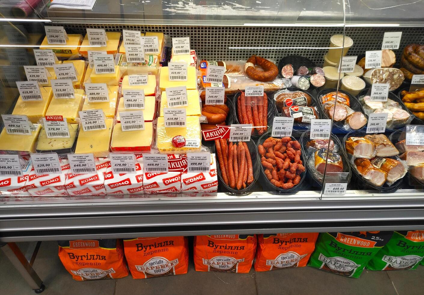 Dnipro, Ukraine - April 26, 2025 - Cheese blocks and smoked sausages displayed in supermarket deli counter. Concept of grocery shopping, delicious cheese selection, smoked meat variety photo