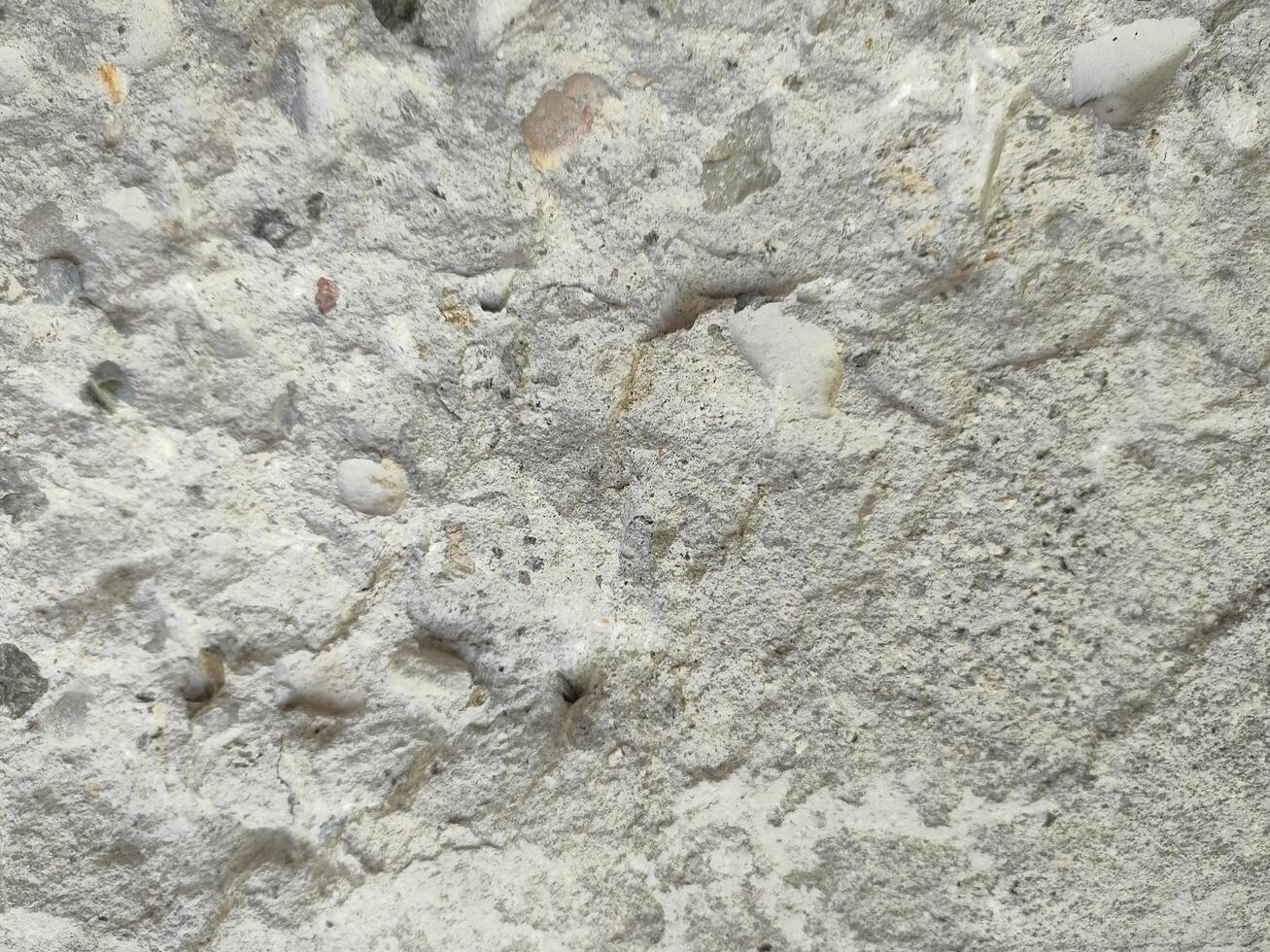 Close-up of a weathered concrete surface showing detailed texture and imperfections. photo
