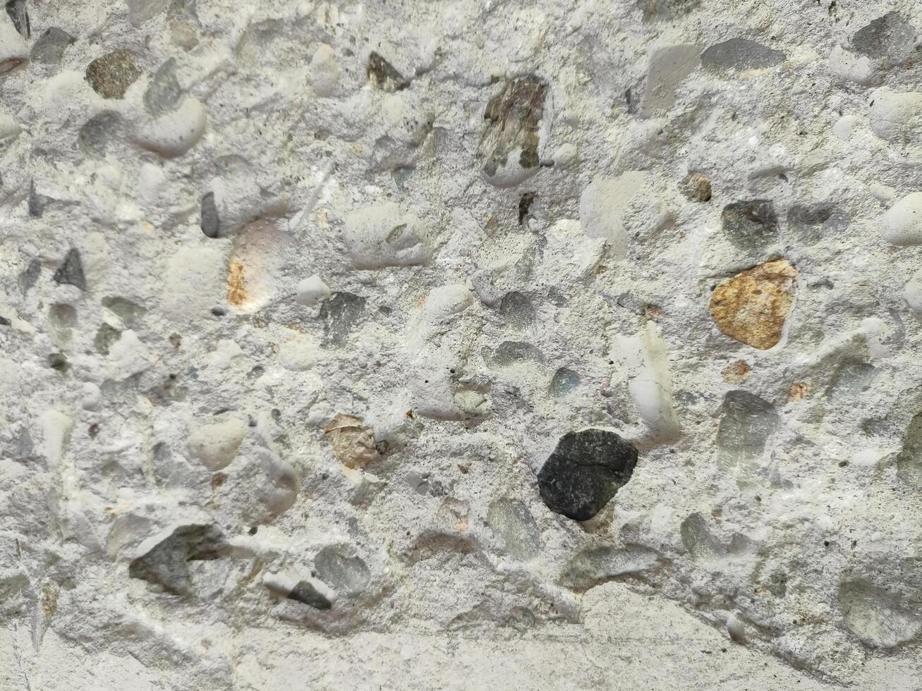 Close-up of concrete texture with aggregate stones and rough surface. photo