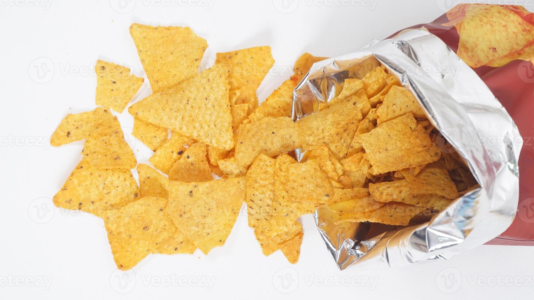 Tortilla chips spilled out from tortilla bag isolated on white background photo