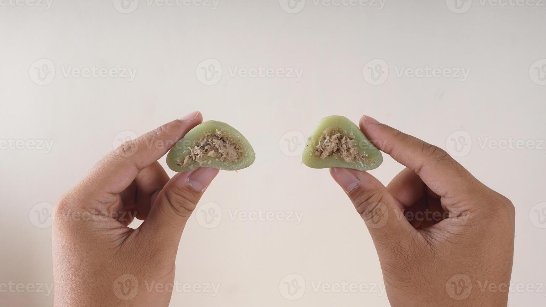 Hands holding traditional Indonesian snack dessert made from glutinous rice flour, Kue Bugis photo