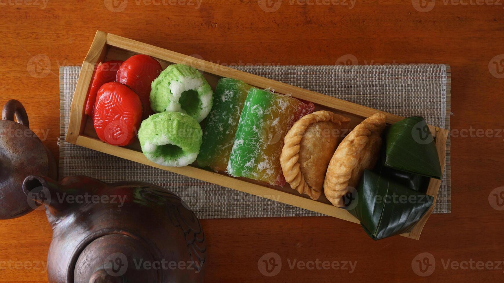 A wooden tray full of several kinds of traditional market snacks from Indonesia or jajanan pasar photo