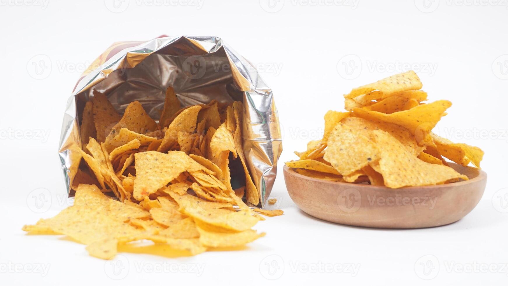 Tortilla chips spilled out from tortilla bag with a plate of tortilla isolated on white background photo