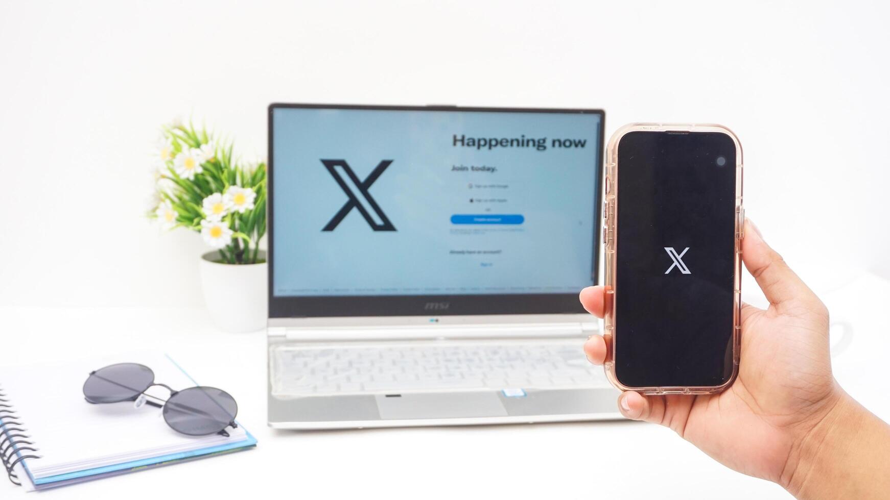 Yogyakarta, Indonesia, 2025 - Hand with smartphone that shows front page of X application former Twitter, social media platform on the screen isolated on white background photo
