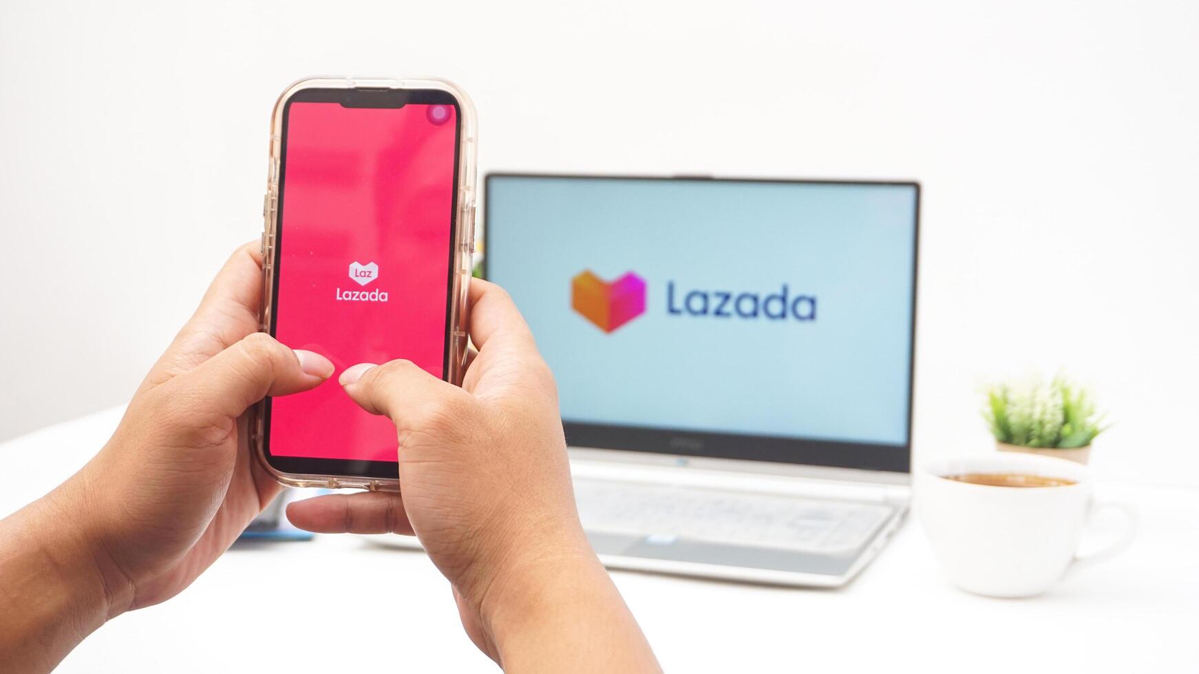 Yogyakarta, Indonesia, 2025 - Hand holding smartphone that shows front page of Lazada e-commerce platform application on the screen isolated on white background photo