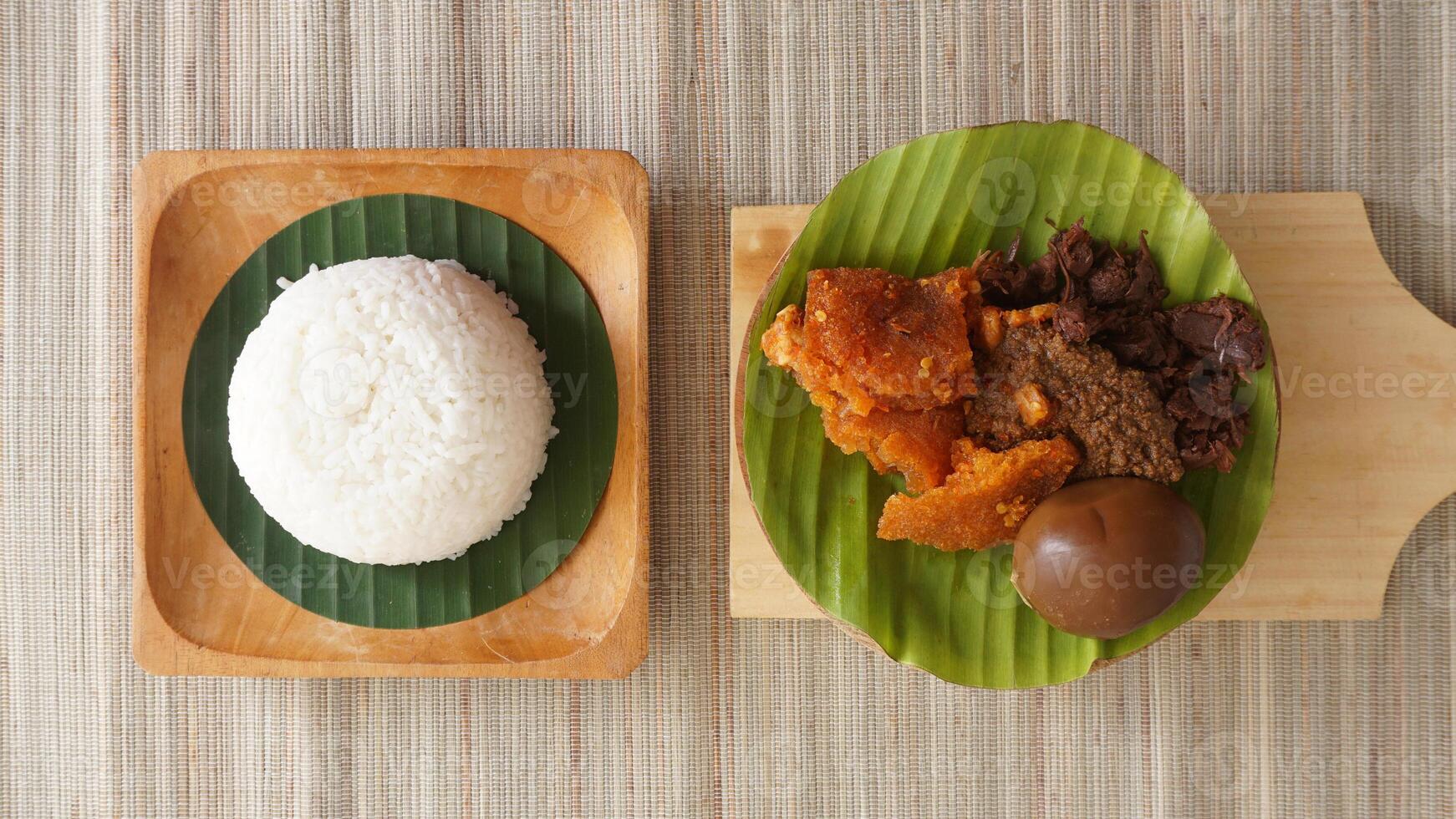 Top view of Gudeg, a popular traditional Javanese dish from Yogyakarta, Indonesia, made primarily from young unripe jackfruit or nangka with several side dishes photo