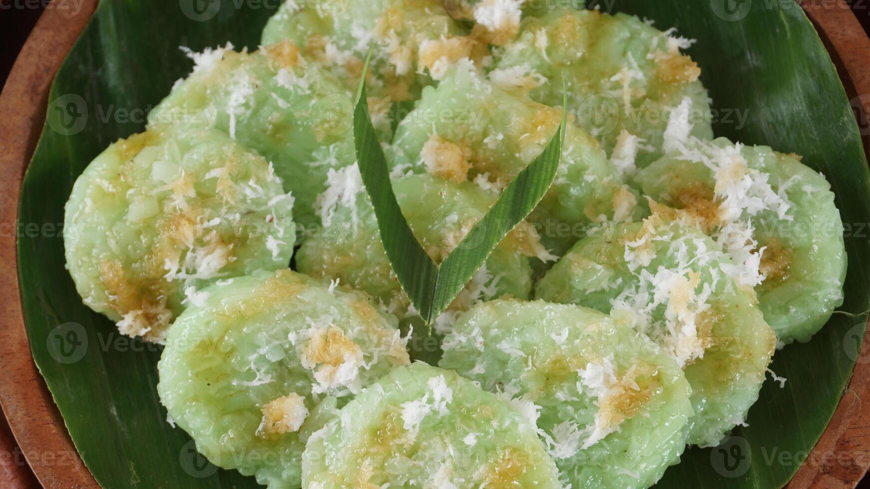 Kue Lupis, delicious traditional Indonesia rice cake snack with grated coconut and palm sugar syrup photo