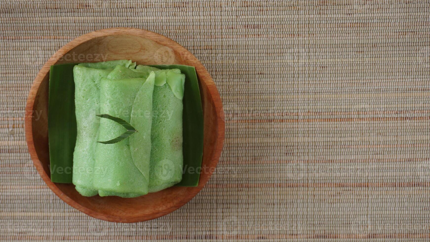 Top view of Dadar Gulung, traditional Indonesia roll crepe on wooden plate photo