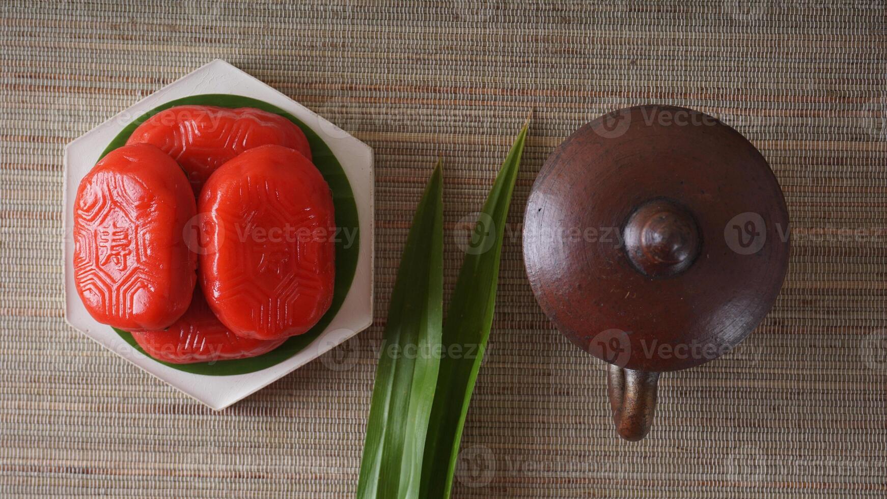 Top view of Kue Mata Kebo means buffalo eye cake, traditional Indonesian snack made from glutinous rice flour, on white platter with pottery tea cup photo