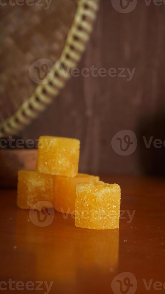 Stack of yellow rock sugar isolated on rustic background photo