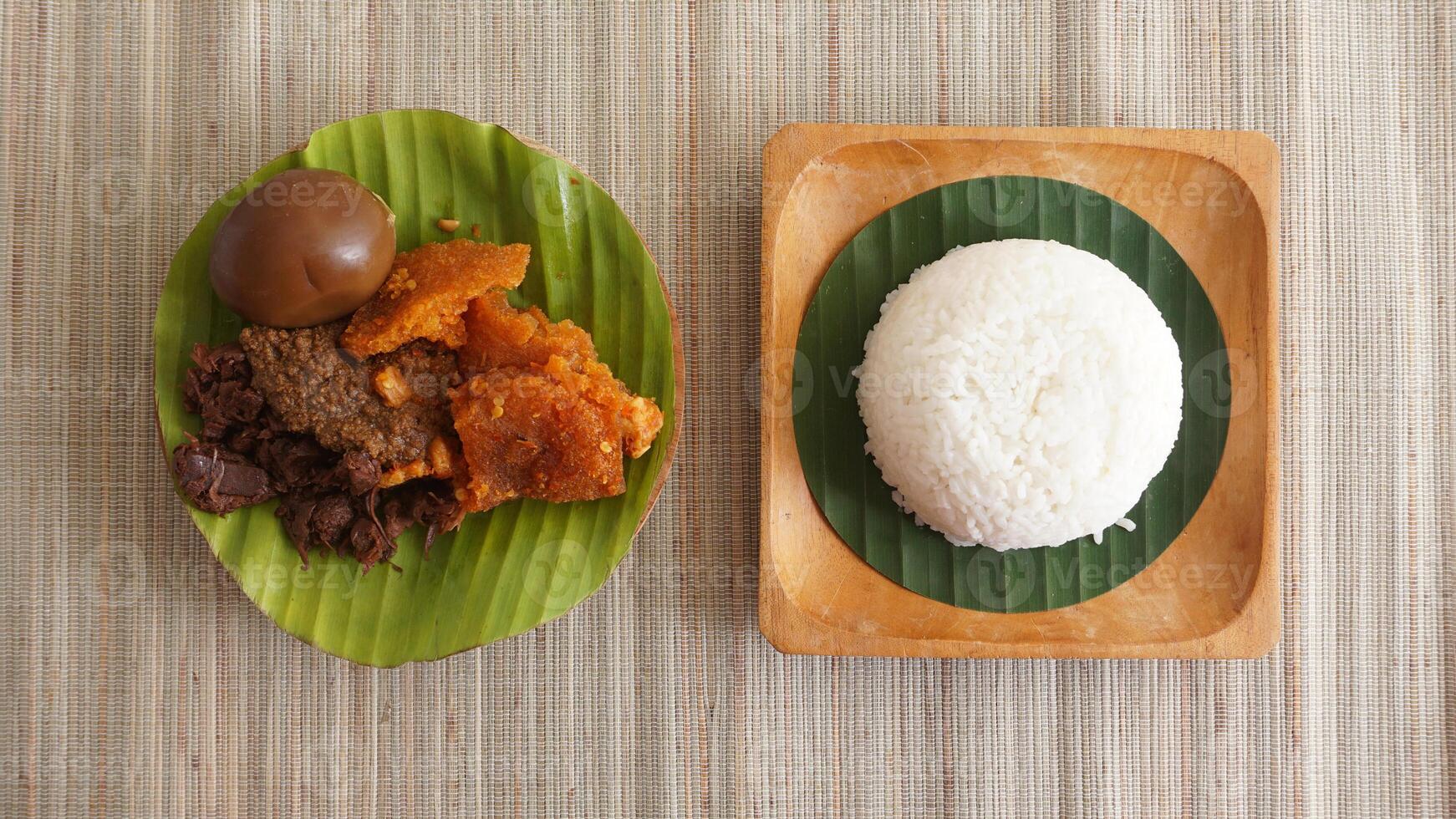 Top view of Gudeg, a delicious traditional Javanese dish from Yogyakarta, Indonesia, made primarily from young unripe jackfruit or nangka with several side dishes photo