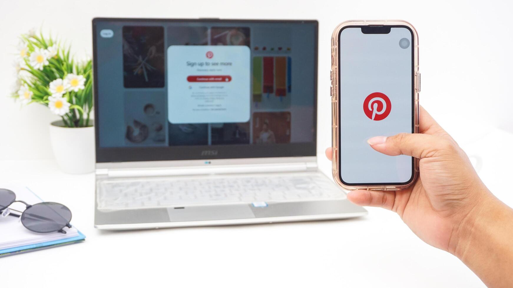Yogyakarta, Indonesia, 2025 - Hand holding smartphone that shows front page of Pinterest, visual discovery platform application on the screen isolated on white background photo