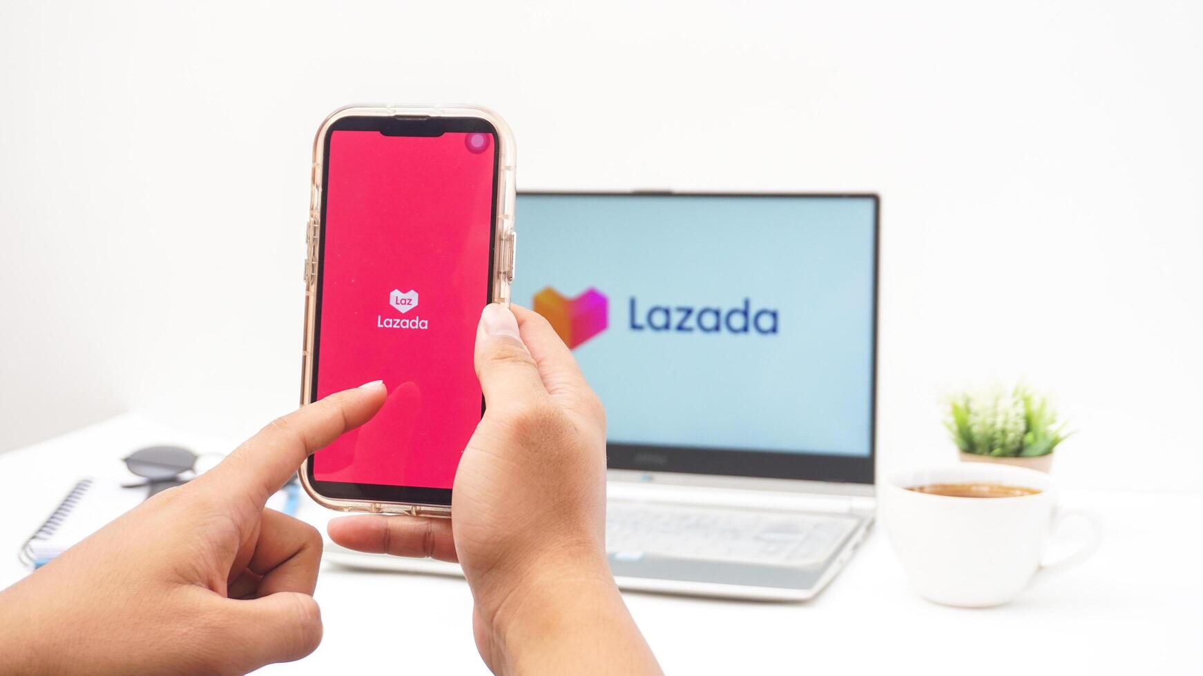 Yogyakarta, Indonesia, 2025 - Hand using smartphone that shows front page of Lazada e-commerce platform application on the screen isolated on white background photo