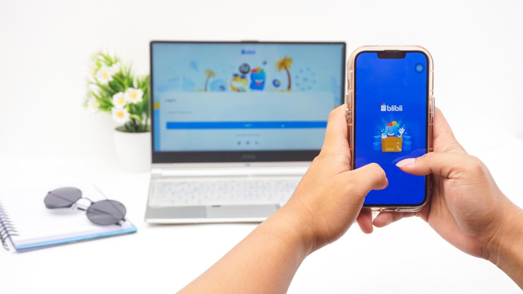 Yogyakarta, Indonesia, 2025 -Hand with smartphone that shows opening page of Blibli, e-commerce platform from Indonesia, isolated on white background photo