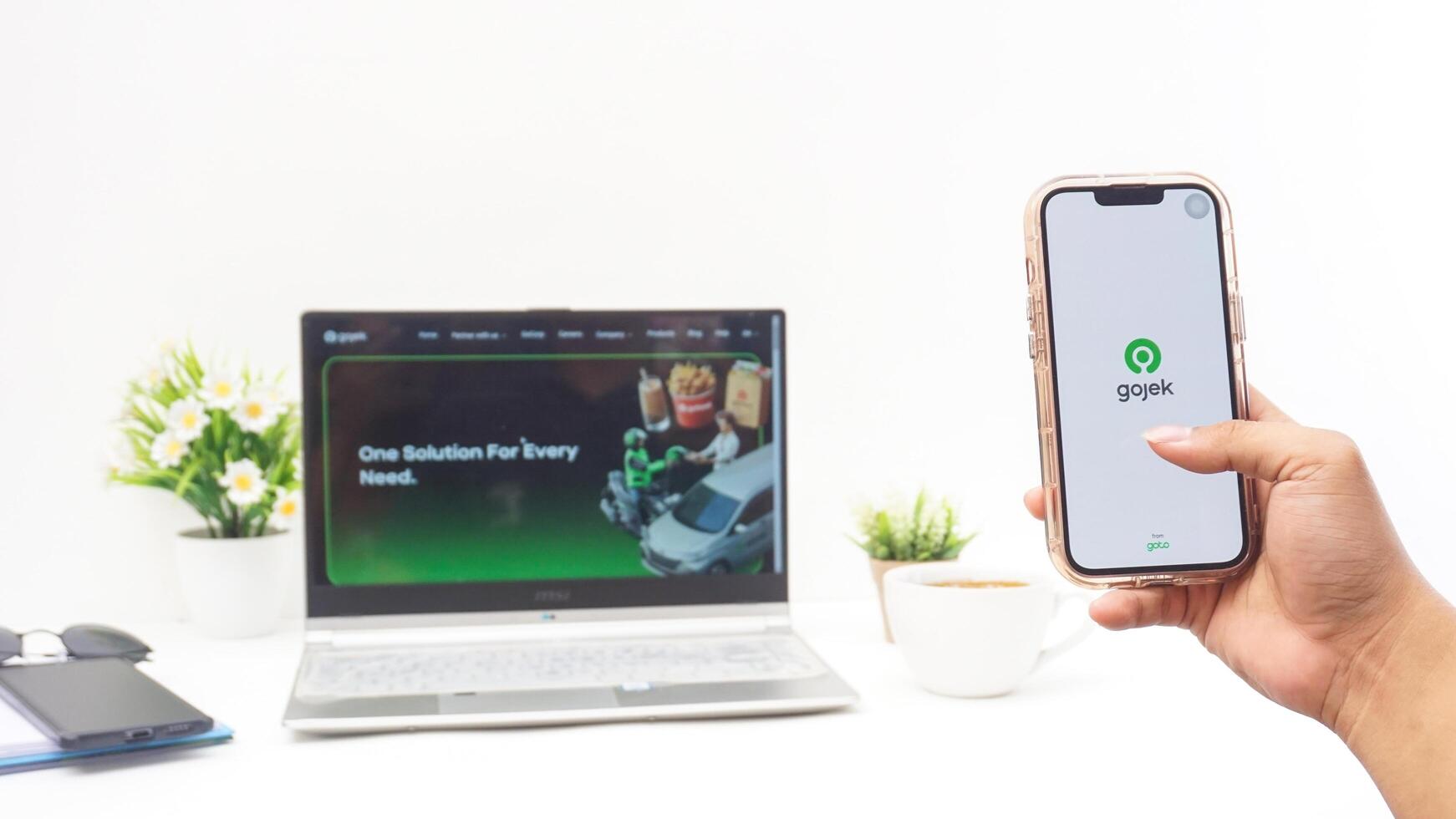 Yogyakarta, Indonesia, 2025 -Hand holding smartphone that shows front page of Gojek application, on-demand service platforms from Indonesia, on the screen isolated on white background photo