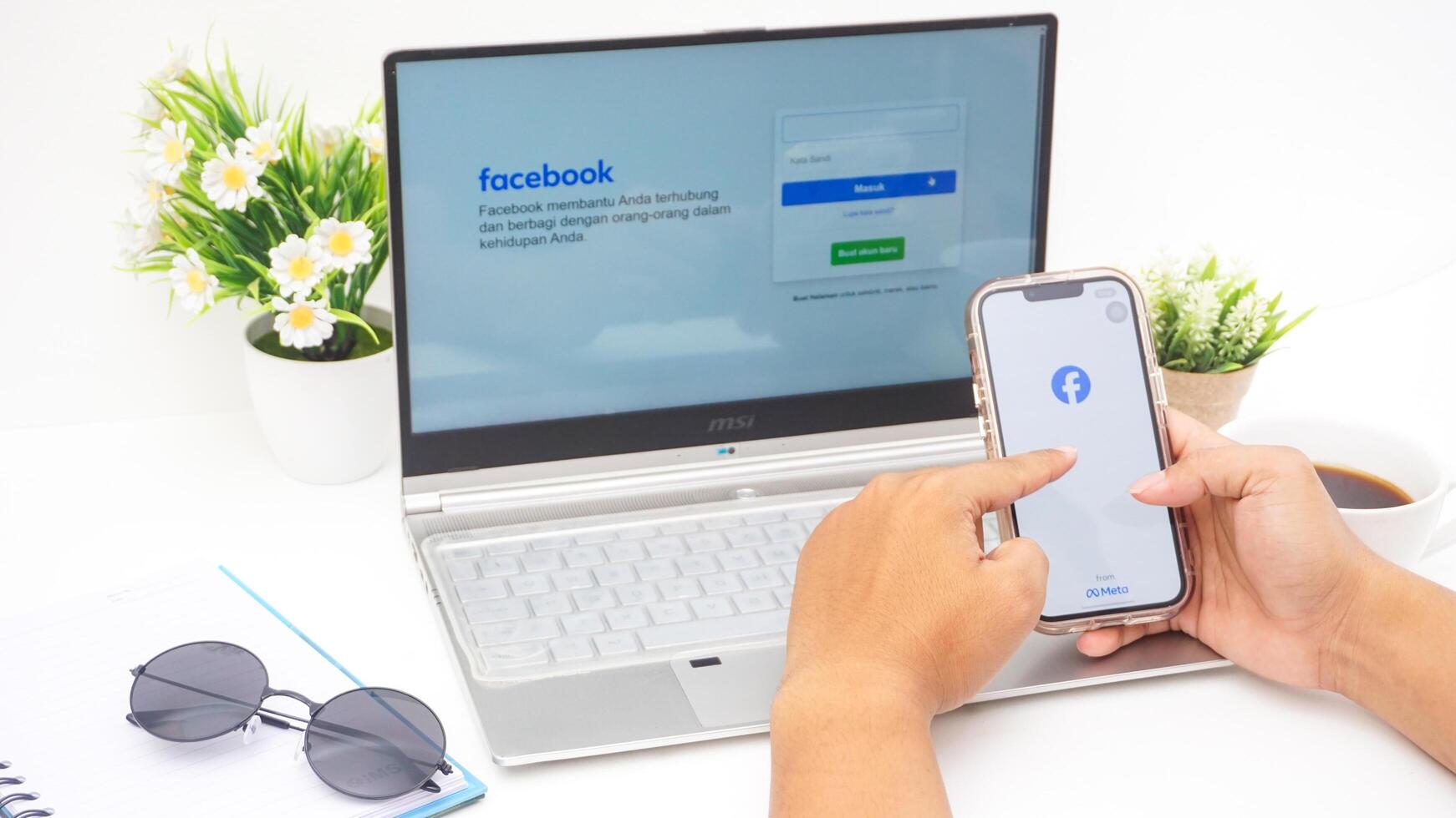 Yogyakarta, Indonesia, 2025 -Hand with smartphone that shows front page of Facebook, social networking service application on the screen isolated on white background photo