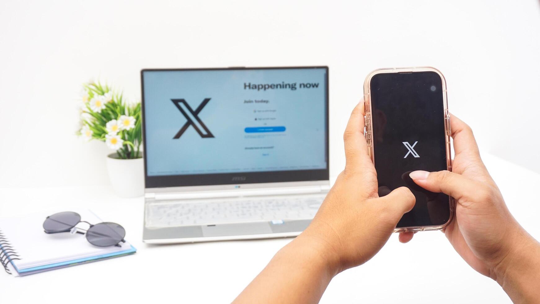 Yogyakarta, Indonesia, 2025 - Hand using smartphone that shows front page of X application former Twitter, social media platform on the screen isolated on white background photo