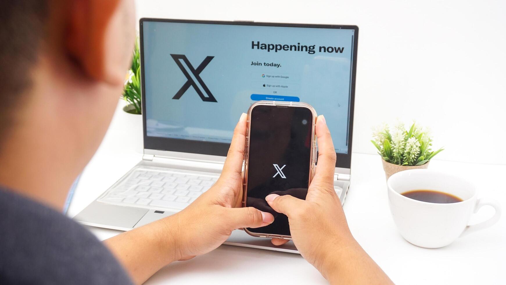 Yogyakarta, Indonesia, 2025 - Man with smartphone that shows icon of X application former Twitter, social media platform on the screen isolated on white background photo