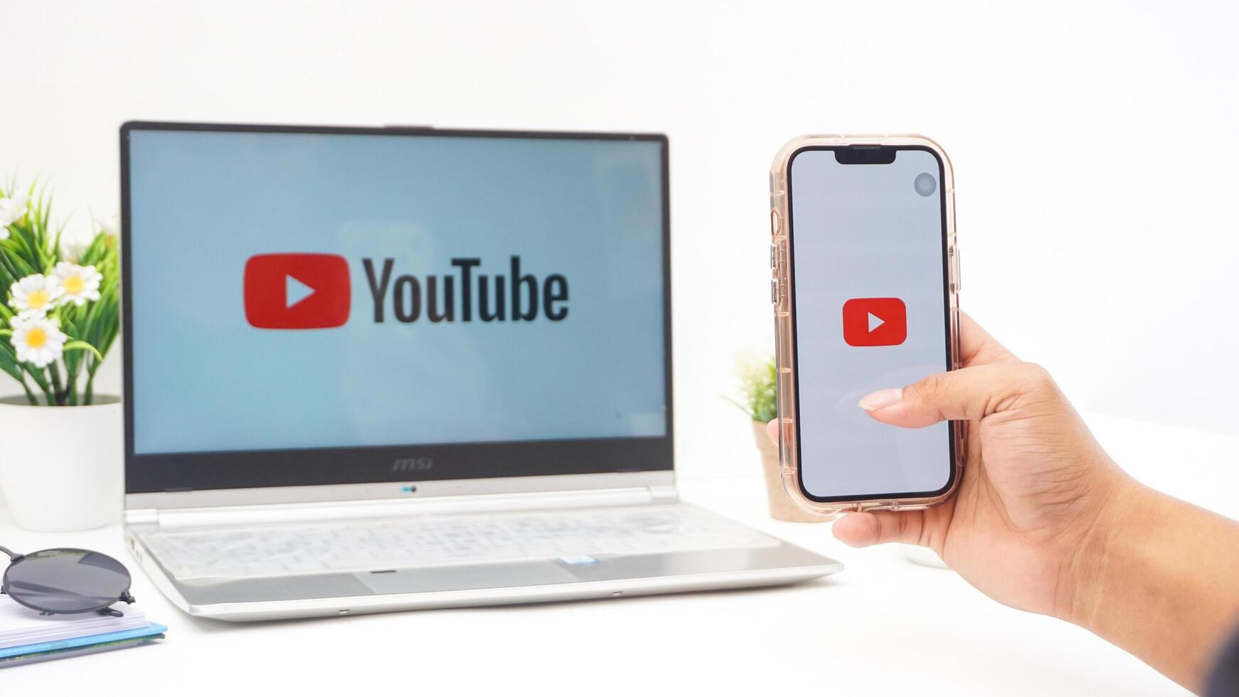 Yogyakarta, Indonesia, 2025 - Hand holding smartphone that shows front page of Youtube platform application on the screen isolated on white background photo