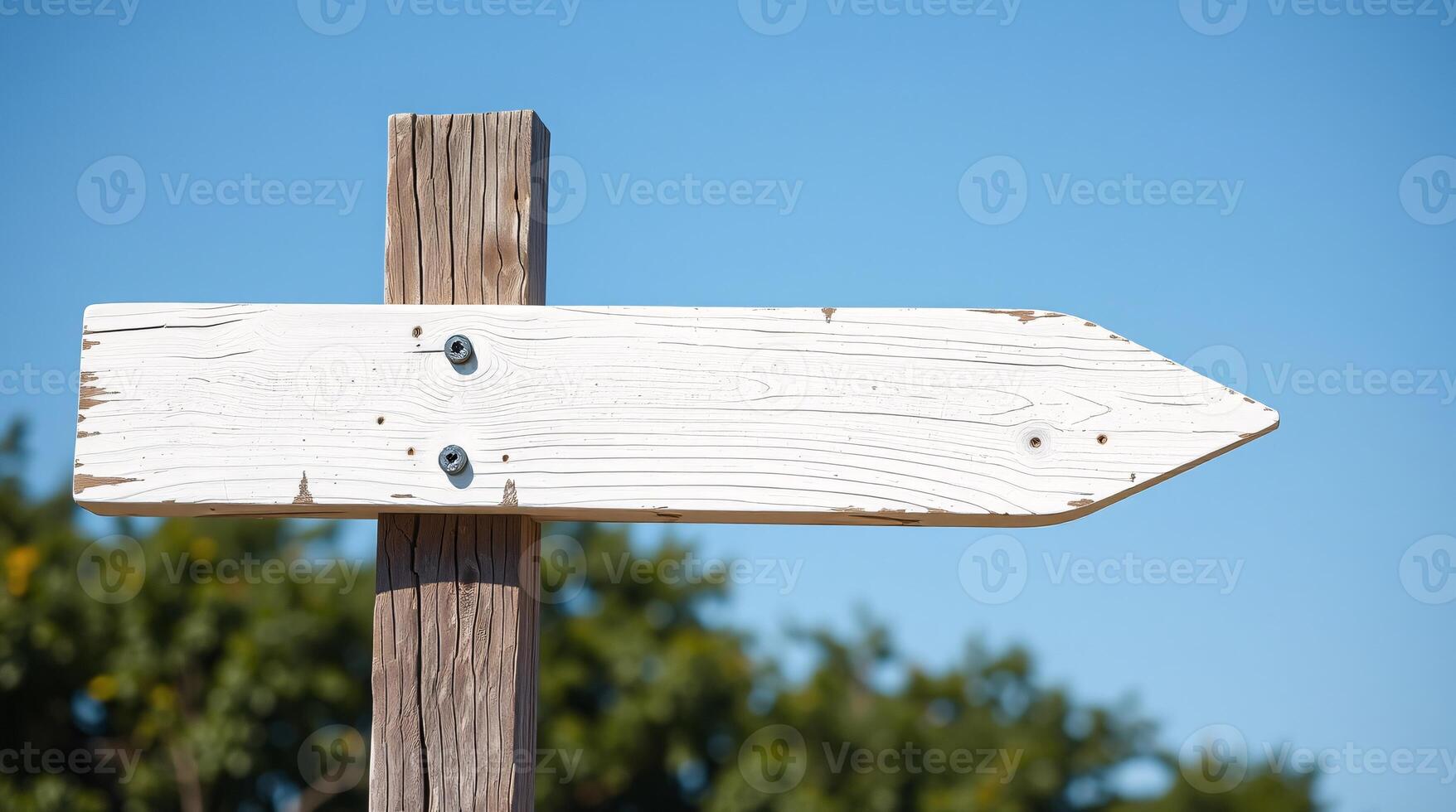 A weathered wooden signpost pointing the way wooden old white sign and a blue sky in the background. photo
