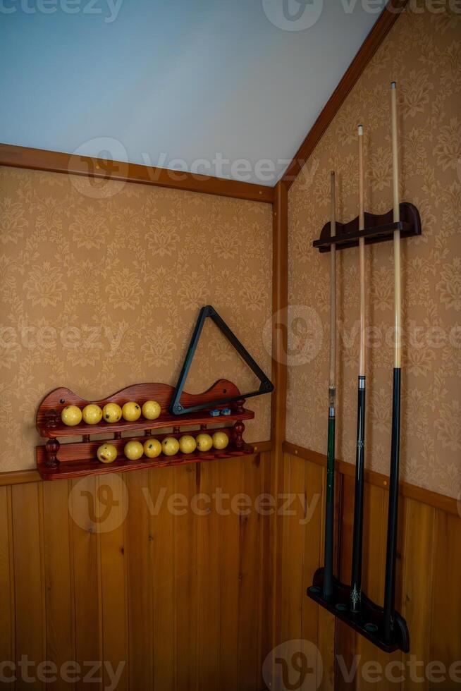 Home billiard setup with white balls, red cue ball, triangle rack, and cues neatly arranged. Concept of indoor recreation and personal hobby space. High quality photo