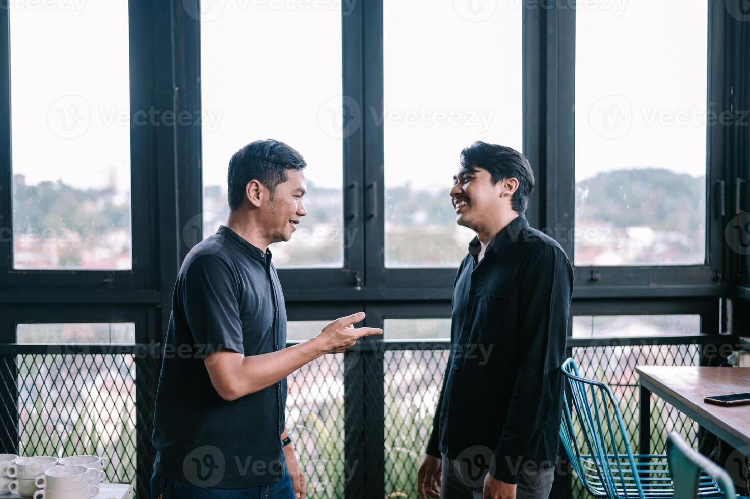 Two happy men having a casual conversation in a cozy indoor space photo