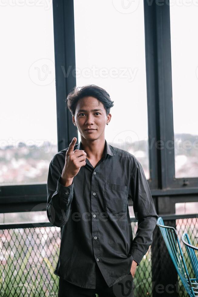 Young man points up in modern setting, expressing an idea or concept photo