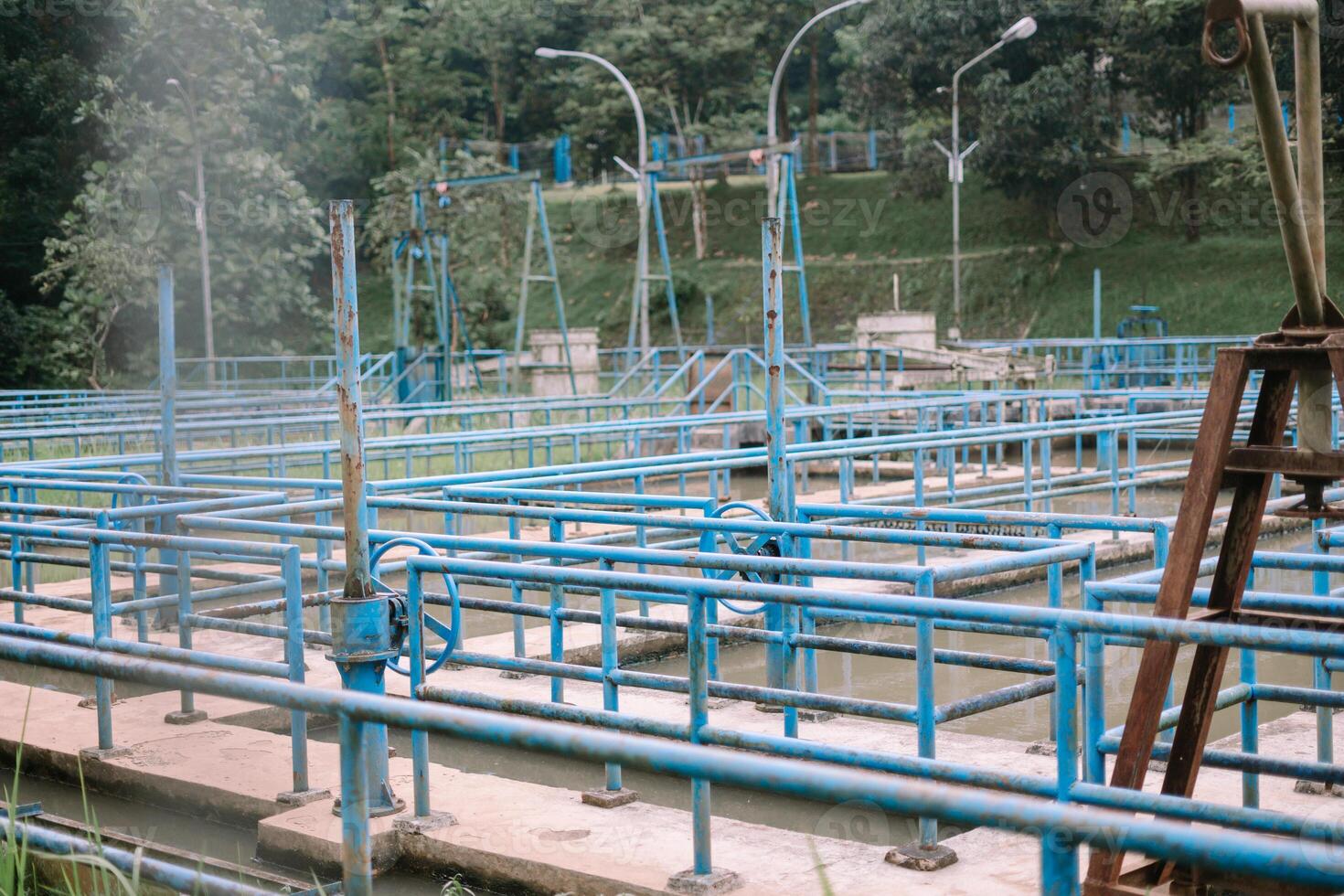 Water treatment facility with blue railings and nature background photo