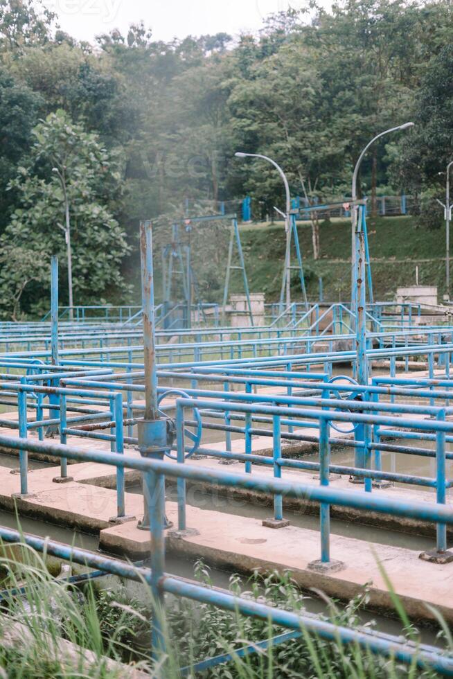 Water treatment facility with intricate blue pipes and natural backdrop photo