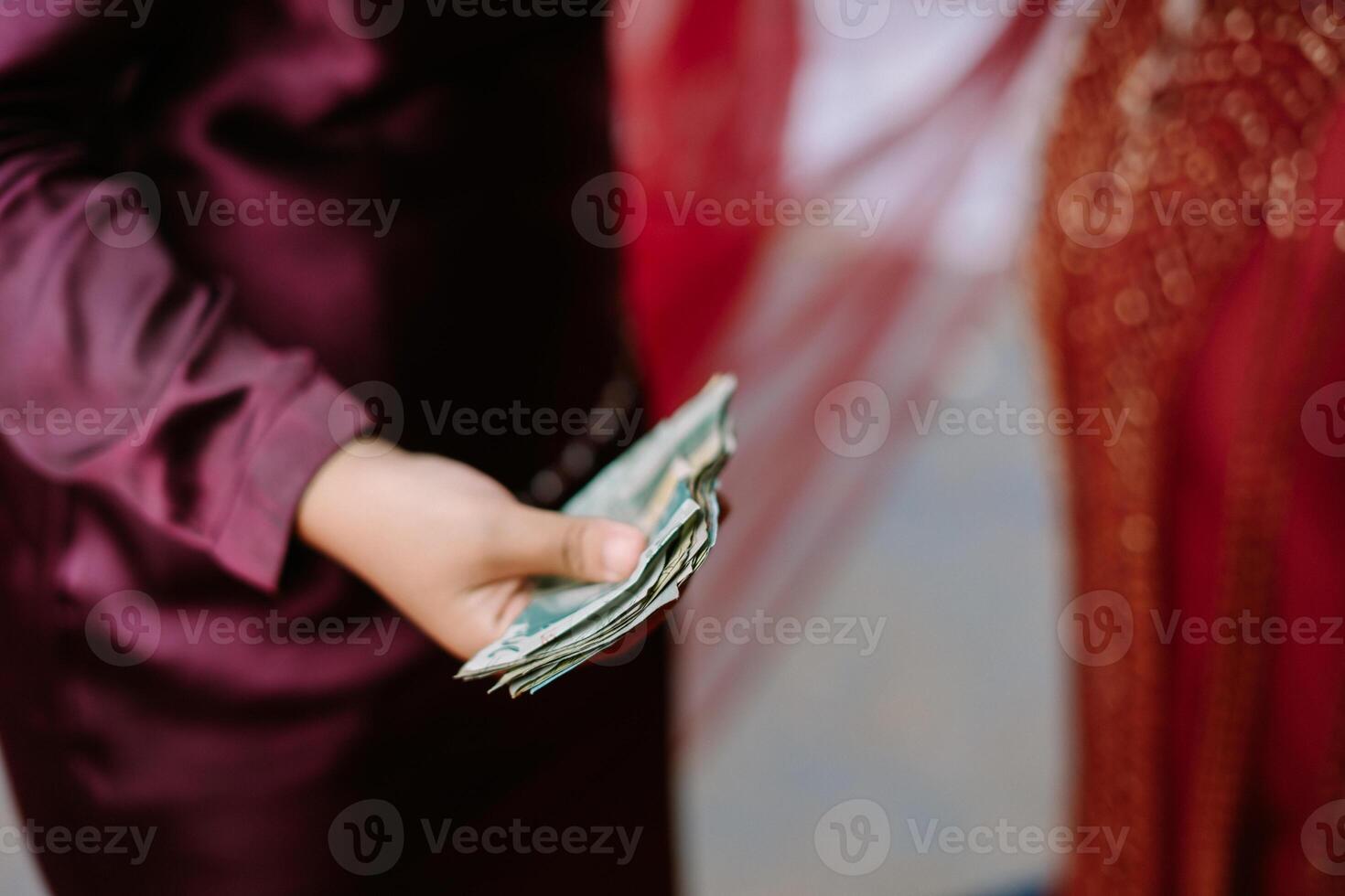 Close up of money being given at a traditional Malay wedding ceremony photo