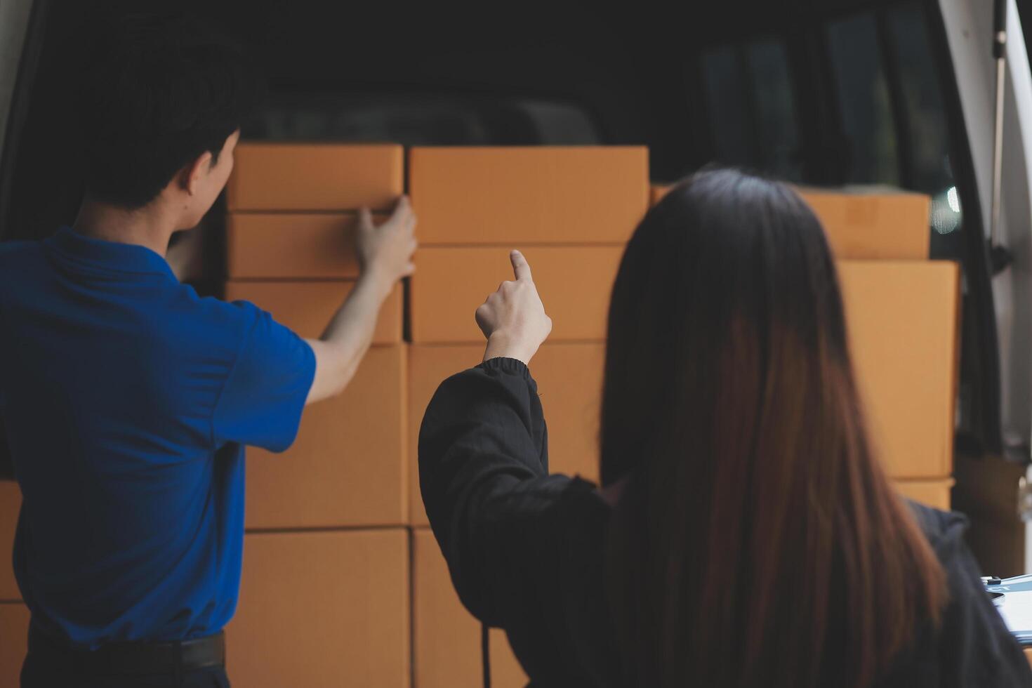 A man and woman are loading boxes into a van photo