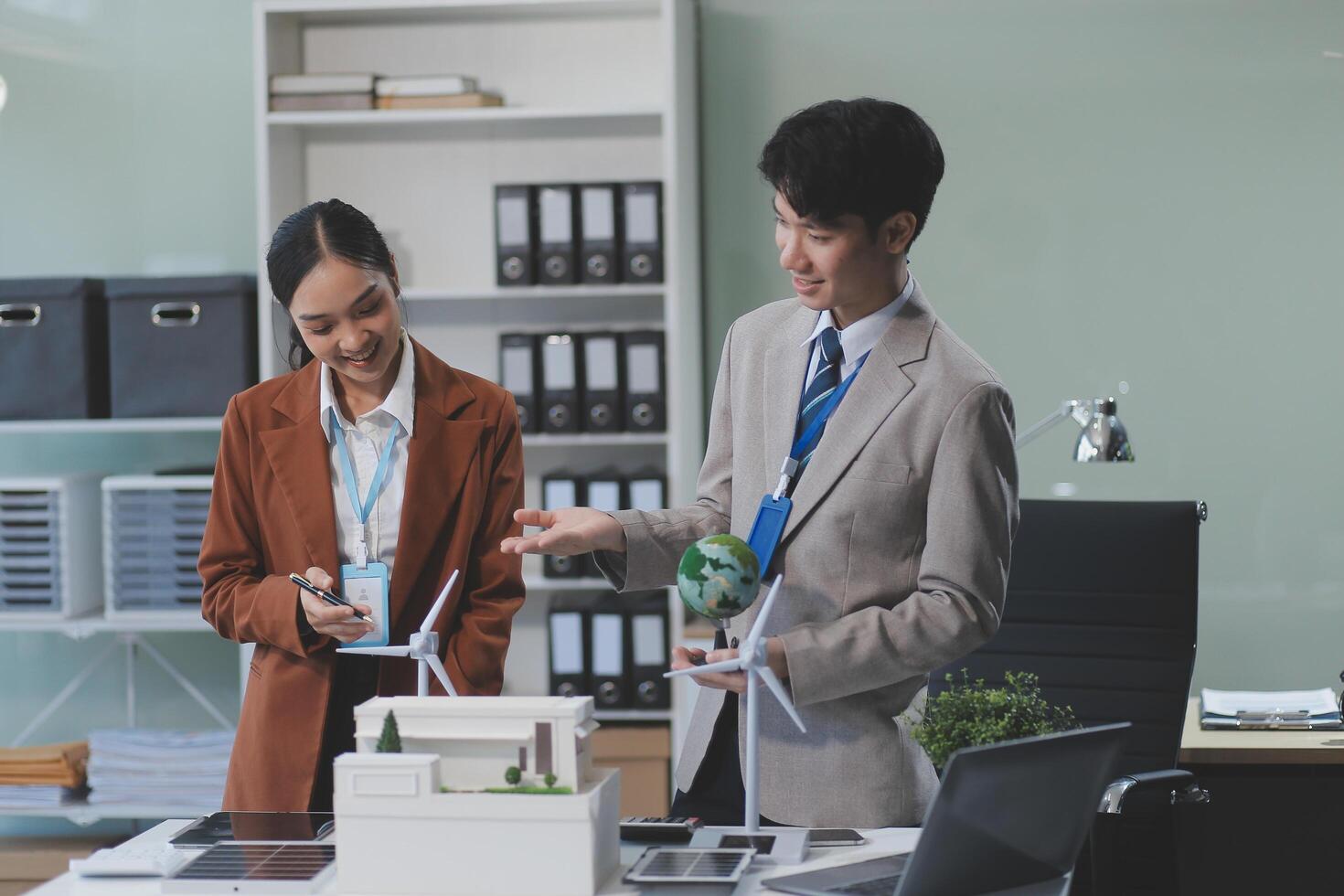 Two business people standing in front of a desk photo