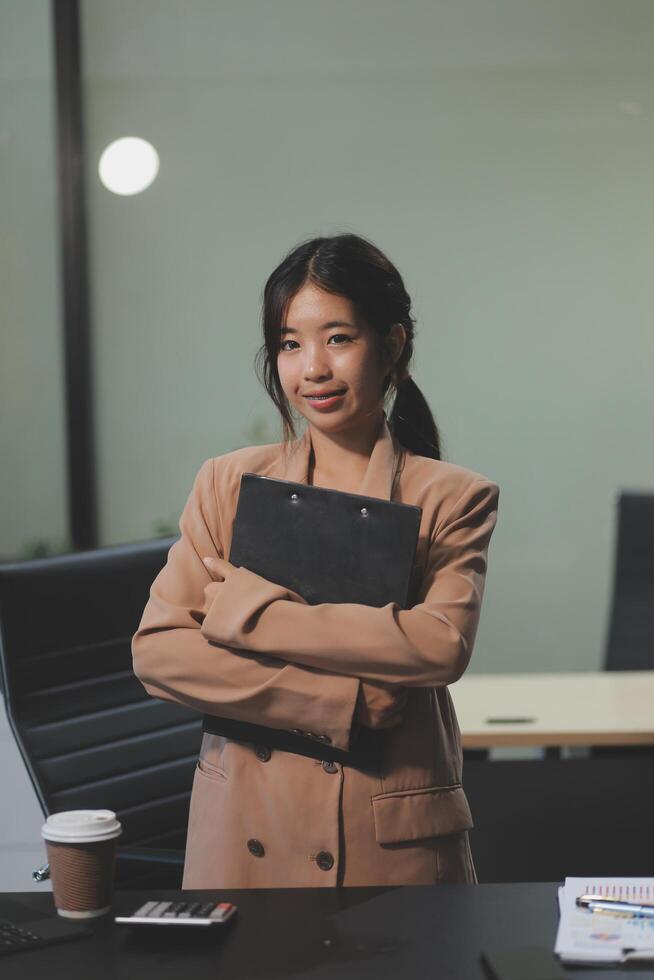 A woman in a business suit standing in front of a desk photo