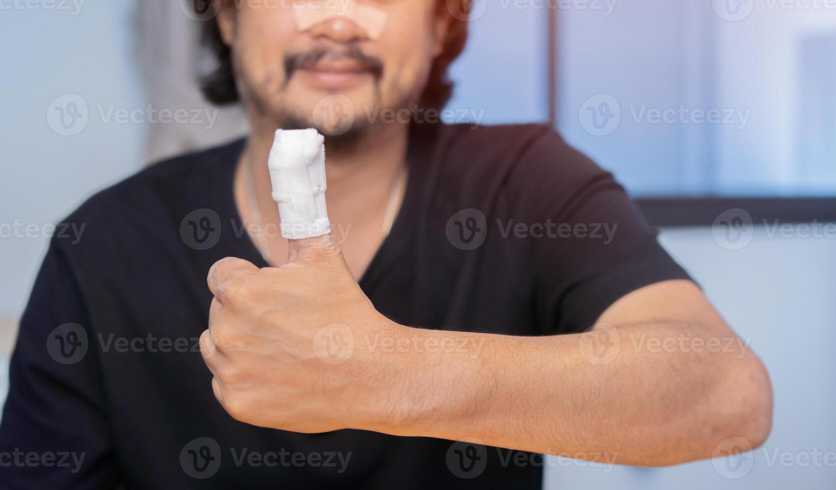 Shot image of Asian man show his fingers in a bandage, finger injury in a man, thumb gauze bandage. photo