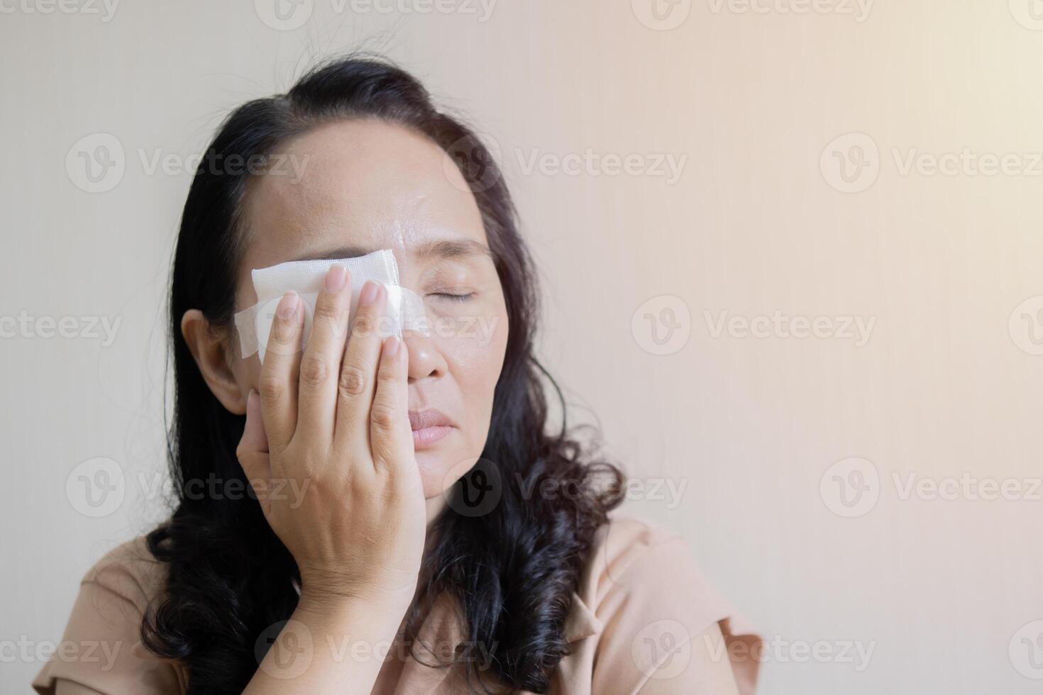Asian women with gauze feel tired and eyestrain after an eye infection. photo