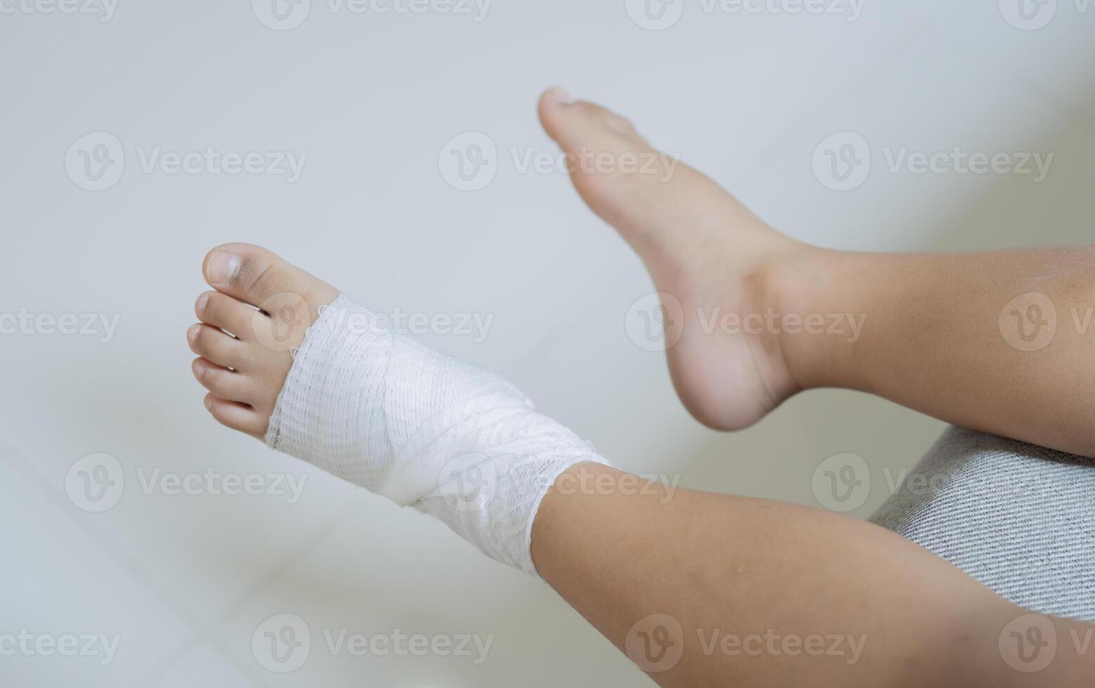 Top view of bandaged feet of a child because of a little accident after falling down. photo
