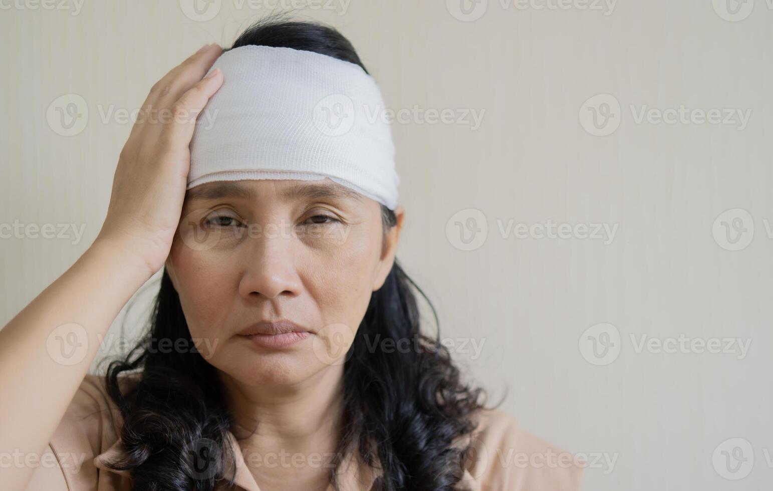 White bandage on Asian woman brain concussion wound head. Close-up photo