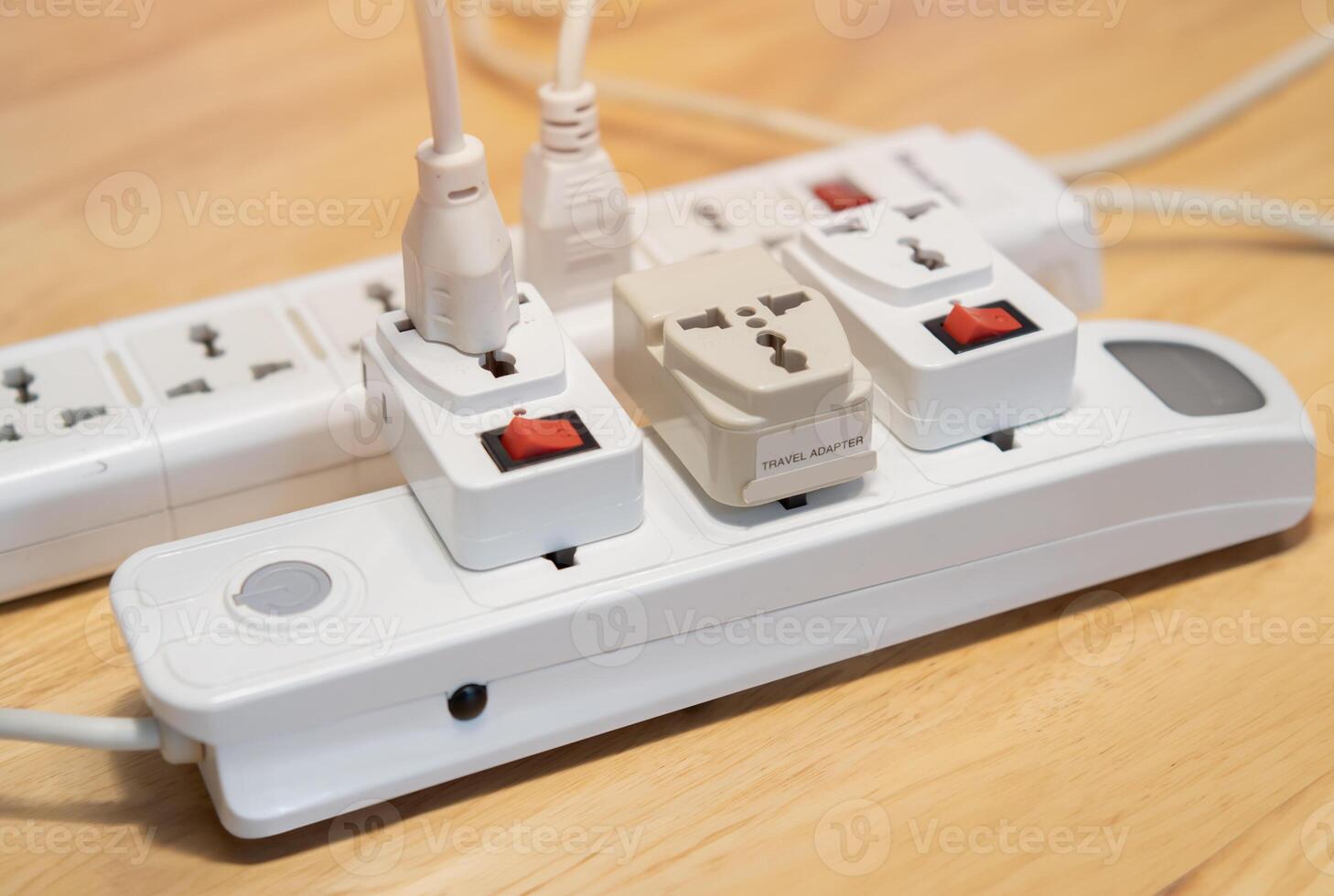 Cropped image of extension cord on wooden floor at home. Electrician's equipment concept. photo