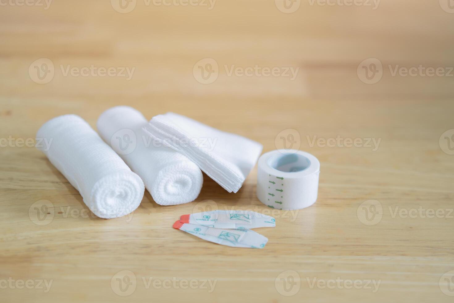 Gauze, ace bandage, tape, bactericidal patches and bandages shot on wooden background. photo