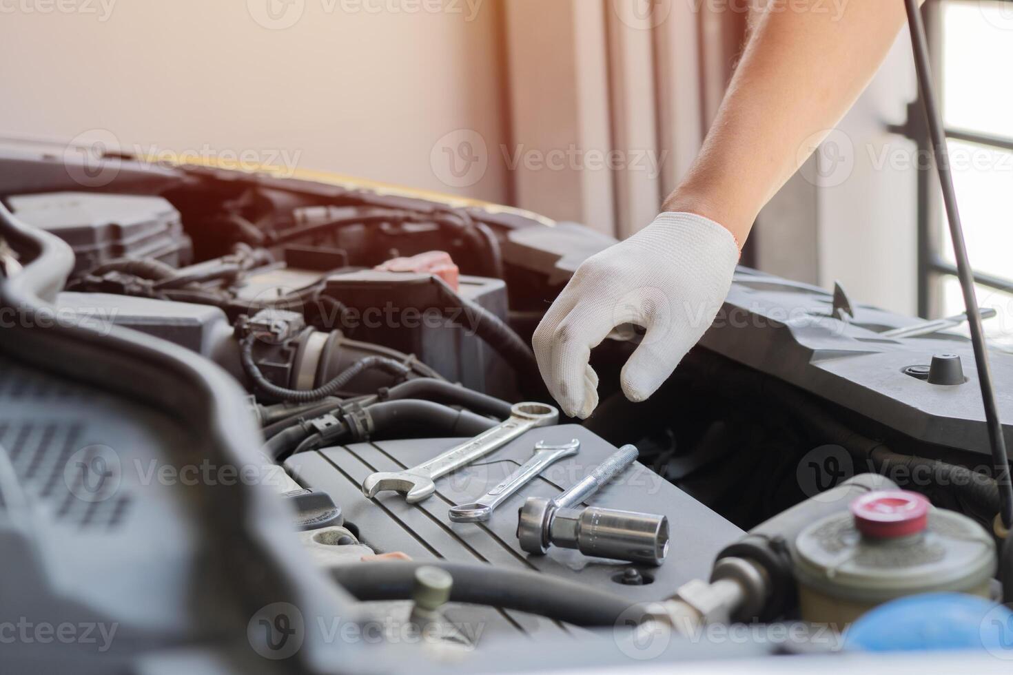 Hand of auto mechanic with a wrench. Male mechanics's hand at the garage fixing a car. photo